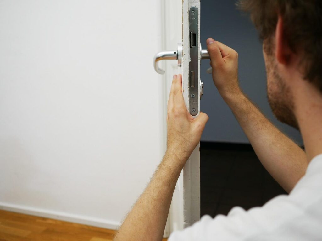 Professionele slotenmaker aan het werk met slot en gereedschap voor reparatie en beveiliging